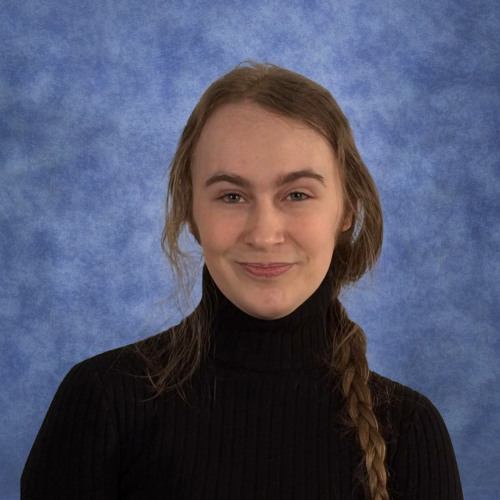 Smiling young person in a black turtleneck.